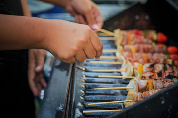 Asian men are cooking for a group of family to eat barbecue (BBQ) grill for family enjoying christmas and New Year.