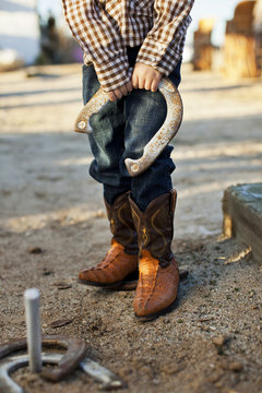 Little Boy With Cowboy Boots And Horseshoe