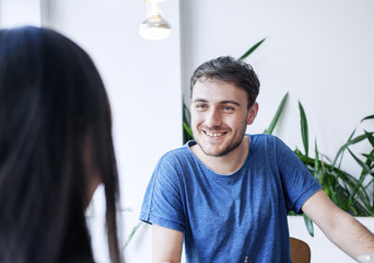 Young man talking to a coworker.
