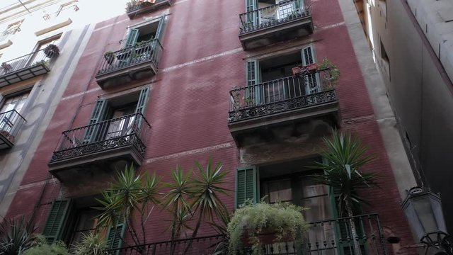 Apartment building streets in Barceloneta area. House with balconies in Barcelona's Gothic Quarter. Facades of old houses in the narrow streets of Barcelona. Traveling concept. Slow motion.