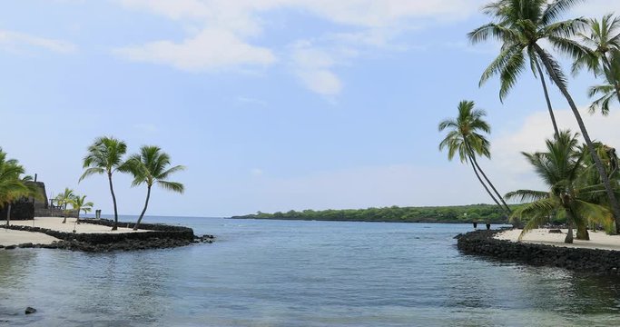 Couple Pu uhonua o Hanaunau historical park tropical. Tropical wonderland. Big Island, largest, most volcanic active location. Economy is tourism based. Water and tropical beach recreation and fun.