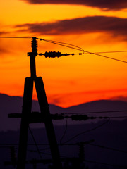 Izolatory energetyczne na tle czerwonego nieba © JDziedzic