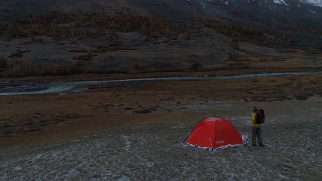 The man near the tent on the background of mountain landscape. aerial 4k