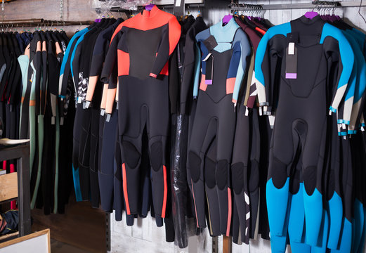 Image of colorful wetsuit hanging in the shop for surfing