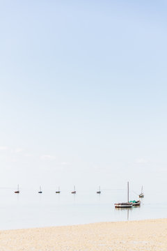 Boats on a calm tropical beach. Vertical shot with copyspace
