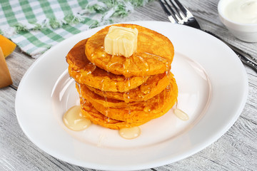 stack of pumpkin pancakes with honey and butter