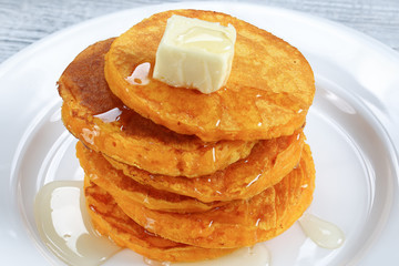 stack of pumpkin pancakes with honey and butter