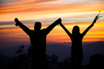 Fototapeta premium Loving couple showing heart symbol on hands,twilight background