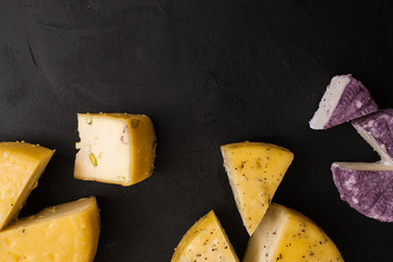 Assortment of dairy gourmet milk products, top view free space. Quality sorts of winery cheese and Caciotta with herbs and pistachio