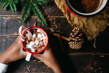 Hands of a child holding a cup of hot cocoa