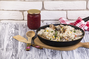 frying pan with fried meat, vegetables and rice