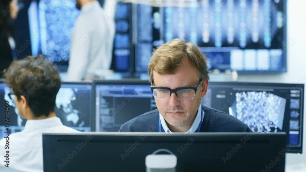 Poster Neural Network Algorithm Architect Working at His Workstation in a Busy Creative Office. Multi-Ethnic Team Works with Multiple Screens Showing AI, Data Mining, Machine Learning Processes.