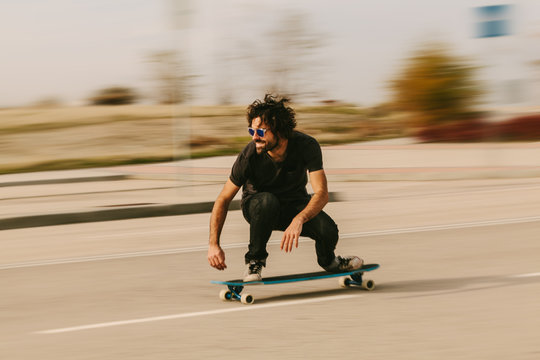 Young Man Longboarding in the Streets