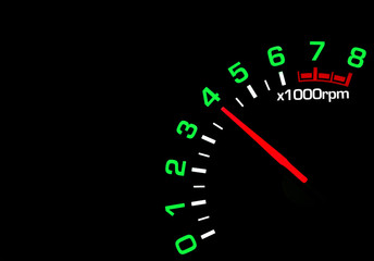 Close up shot of a car speedometer tachometer on black background