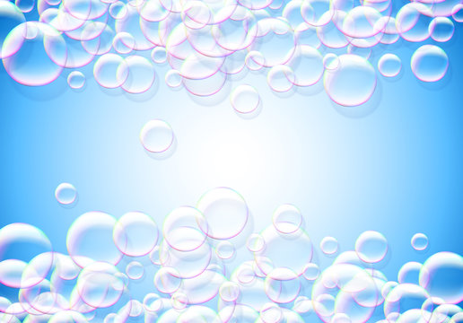 Soap bubbles abstract blue background with rainbow colored airy foam