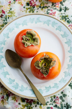 Two persimmons on a plate