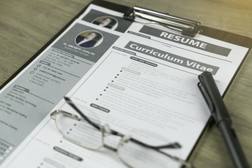 Preparation of Curriculum Vitae and Resume of supply chain manager before submit to headhunter or recruiter concept with glasses and pen on the wooden background