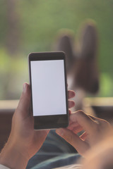 Man lying on a sofa and using cellphone.