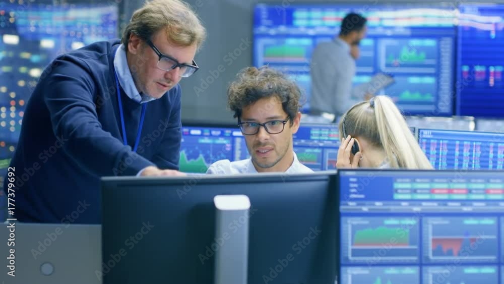 Poster experienced stock exchange trader consults his apprentice at the workstation. multi-ethnic team at s