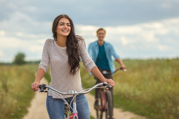 The happy woman riding a bike near the man outdoor