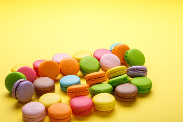 Fototapeta na wymiar A french sweet delicacy, macaroons variety over yellow background