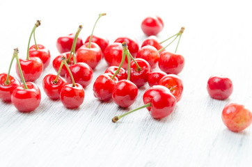 Obraz na płótnie Canvas Cherries on a white background. Red berries with green twigs.