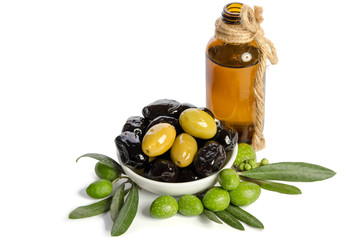 Black and green  olives  mixed in the  porcelain bowl and Virgin olive oil in a crystal bottle isolated on white background