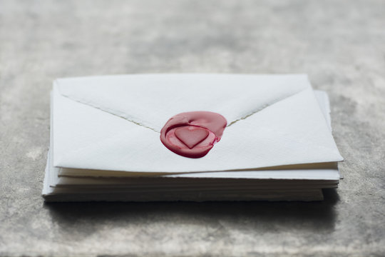 Stack of letters with heart shaped wax seal