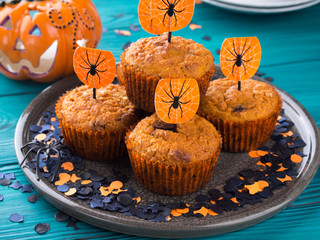 Pumpkin muffins with chocolate chips for Halloween kids party. Holiday decorations