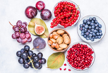 Berries and fruits, nuts healthy antioxidant red and purple food top view.