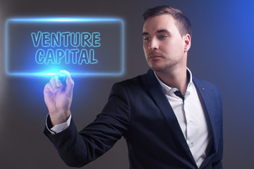 The concept of business, technology, the Internet and the network. Young businessman showing inscription: Venture capital