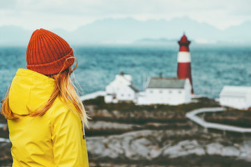 Young woman enjoying Norway lighthouse sea landscape Travel Lifestyle concept adventure scandinavian vacations outdoor
