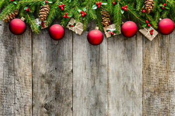 Wooden background with christmas decorations on branches of green fir, frame or christmas card
