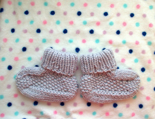 Waiting baby. woolen socks - the first shoes for a newborn baby on a white background in polka dots. the best gift for birth.