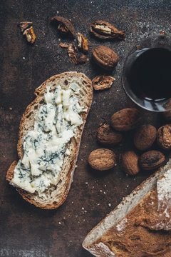 Slice of bread with blue cheese, wine and wallnuts