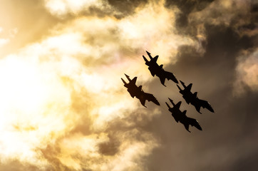 Group of fighter jet airplane sun glow blue sky.