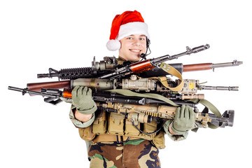 soldier with rifle wearing Santa claus cup and holding cardbox isolated on white background