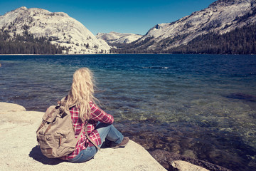 woman sitting at a lake in Yosemite Park. wanderlust concept
