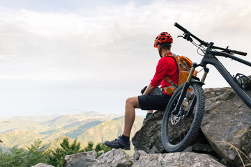 Mountain biker looking at view on bike trail in autumn mountains