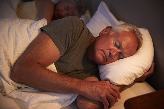 Peaceful Senior Man Asleep In Bed At Night