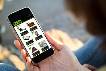 woman sitting in the street shopping on cyber monday her smartphone