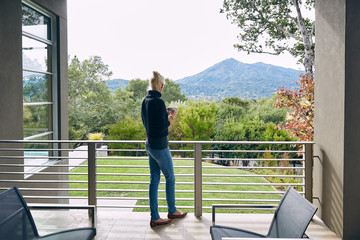Mature woman relaxing on patio at home looking at view