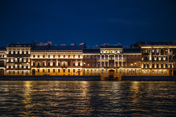 Fototapeta na wymiar Night View of St. Petersburg from Neva River, buildings on embankment with