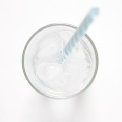 glass with ice cubes on white painted table