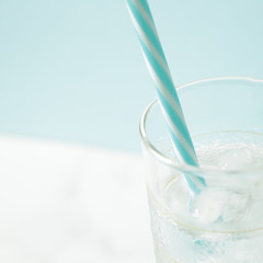 glass with ice cubes on white table