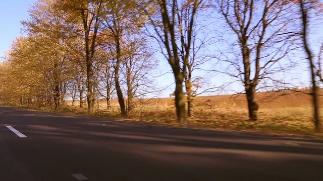 Steadycam shot of motorcyclist driving his motorbike on the road during sunset
