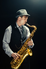 Obraz na płótnie Canvas Young man playing the Saxophone