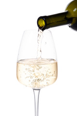 Close-up shot of wine bottle pouring wine in wine glass against white background.