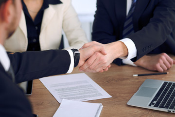 Close up of business people shaking hands at meeting or negotiation in the office. Partners are satisfied because signing contract