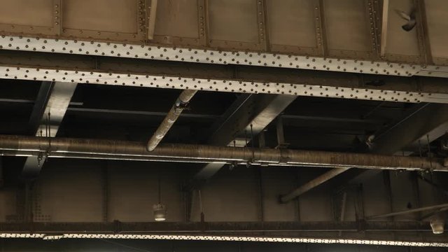Pigeons flying underneath steel bridge in New York City. Slow motion.